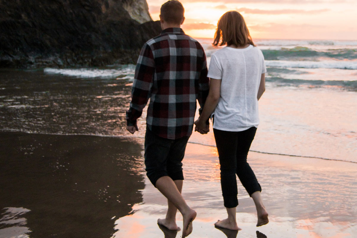 couple walking on beach at sunset  holding hands