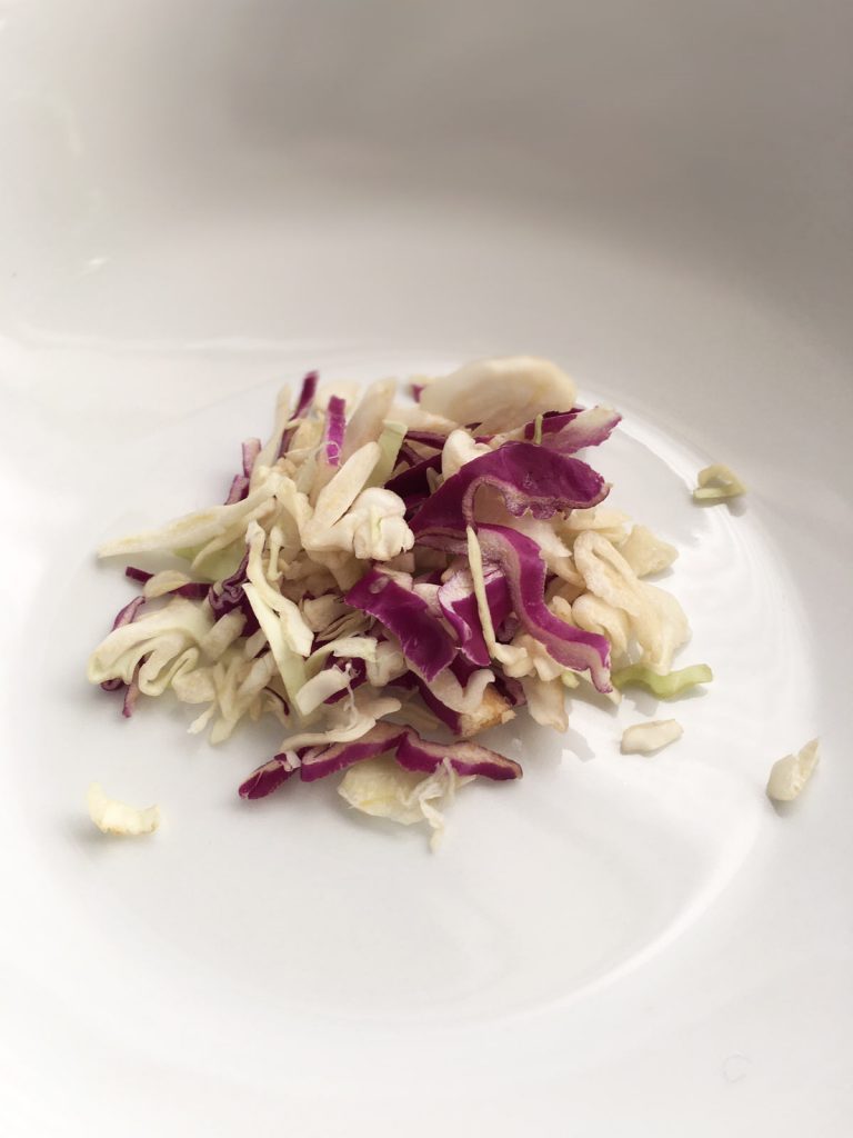 shredded green and purple cabbage in white bowl